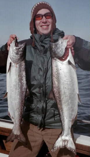 Fish Finders Seattle Fishing Charters- A man carries two big fish