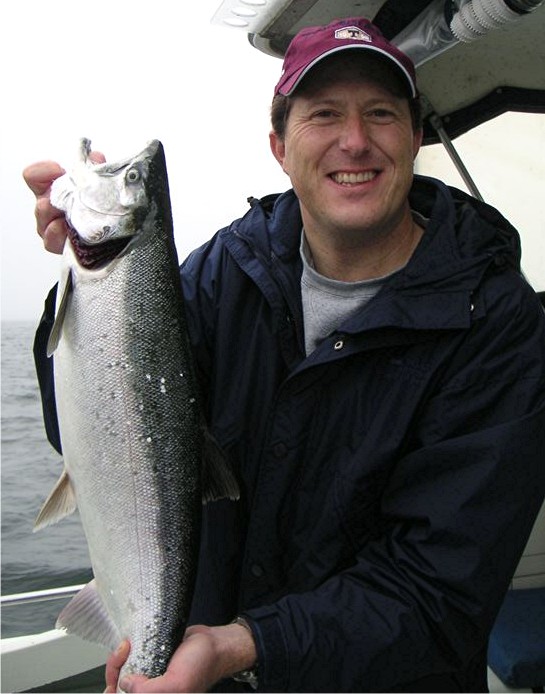 Fish Finders Seattle Fishing Charters- A Man Standing with a Fish