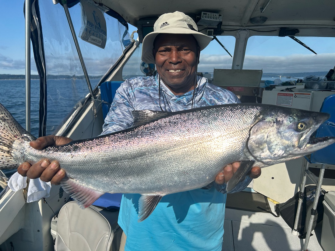 Fish Finders Seattle Fishing Charters- A man carries fish in his hand